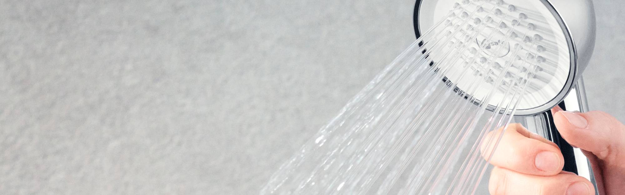 Chrome Hand Shower Filter held by hand, demonstrating maneuverability.