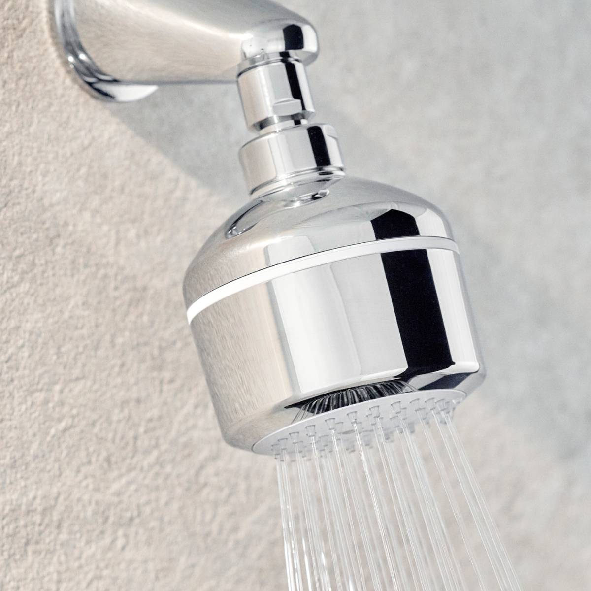 Angled view of Easy-Fix Shower Filter, showing its compact form, mounted to the wall, with a steady stream of water.