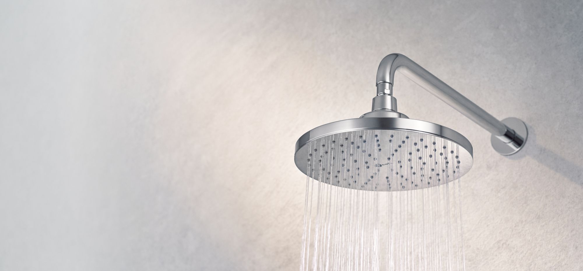 T-safe Aegis Overhead Shower Filter mounted on a wall with water flowing from it in a steady stream.